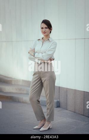 Jeune femme caucasienne dans le bureau ou le style de la mode d'affaires pantsuit dans les tons beiges Banque D'Images