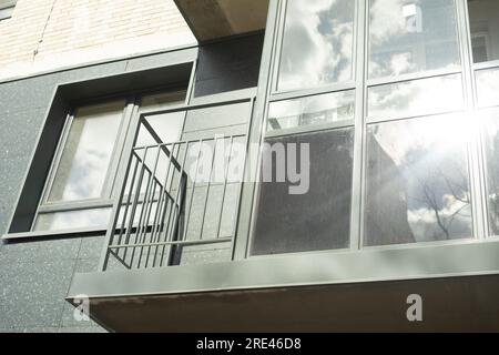 Balcon dans le nouveau bâtiment. Bâtiment résidentiel moderne en détail. Vue extérieure sur le balcon. Revêtement gris de la maison. Banque D'Images