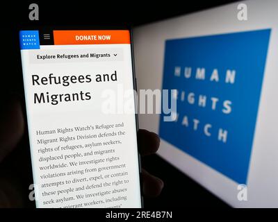 Personne tenant un téléphone portable avec la page Web de l'organisation Human Rights Watch (HRW) sur l'écran devant le logo. Concentrez-vous sur le centre de l'écran du téléphone. Banque D'Images