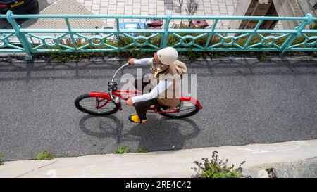 Homme sur un vélo à vélo le long du front de mer de Brighton en été , Sussex , Angleterre Royaume-Uni Banque D'Images