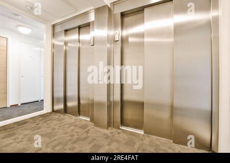 un ascenseur avec deux ascenseurs au milieu et un au deuxième étage, ainsi que c'est à l'intérieur Banque D'Images