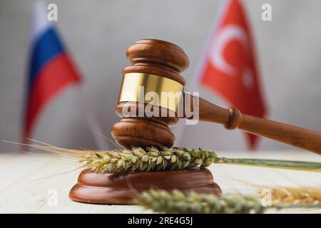 Marteau, blé, épis d'orge et drapeaux des pays sur la table, un concept sur le thème d'un accord céréalier entre la Russie et la Turquie Banque D'Images