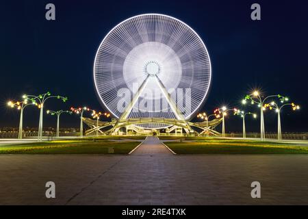 Bakou, Azerbaïdjan - 27 juin 2023 : une photographie fascinante à exposition longue montrant la grande roue éclairée à Bakou. Banque D'Images