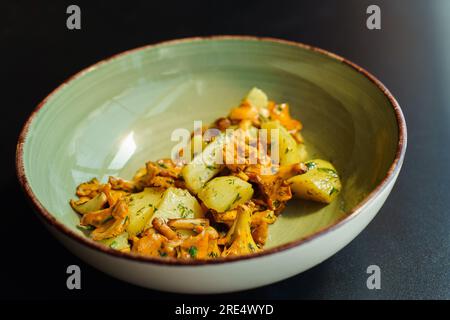 Un bol avec un déjeuner végétarien frais d'été de saison. Chanterelles frites avec pommes de terre bouillies et herbes Banque D'Images