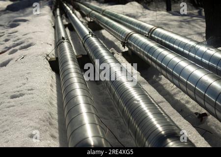 Tuyaux sur la rue en hiver. Tuyaux de chauffage en acier. Détails sur l'industrie. Communications en ville. Banque D'Images