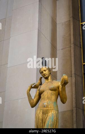 Statue féminine peinte en or avec des pigeons et un vrai pigeon sur le dessus de sa tête devant le Palais de Chaillot (Trocadéro), Paris, France Banque D'Images