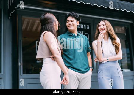 Asian hommes et femmes amis Bonding sur la rue en face de Cozy café. Jeunes amis adultes qui parlent et passent un bon moment ensemble. Concept Youthful Urban Lifestyle Banque D'Images