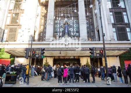 Les gens attendent devant le magasin Selfridges sur Oxford Street à Londres, avant l'ouverture le lendemain de Noël. Banque D'Images