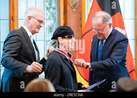 Hanovre, Allemagne. 25 juillet 2023. Stephan Weil (SPD, r), ministre-président de Basse-Saxe, décerne à Klaus Meine (m), chanteur principal du groupe rock 'Scorpionss', la Grande Croix du mérite de l'ordre du mérite de Basse-Saxe à la maison d'hôtes du gouvernement de l'État. Trois membres du groupe rock 'Scorpions' sont honorés pour leur musique ainsi que pour leur engagement honorifique en Basse-Saxe. Crédit : Michael Matthey/dpa/Alamy Live News Banque D'Images