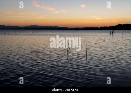 Lac avec jetée au coucher du soleil. Paysage italien relaxant au coucher du soleil en automne. Lac Trasimeno au coucher du soleil Banque D'Images