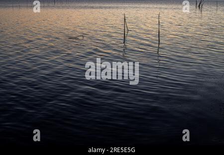 Lac avec jetée au coucher du soleil. Paysage italien relaxant au coucher du soleil en automne. Lac Trasimeno au coucher du soleil Banque D'Images