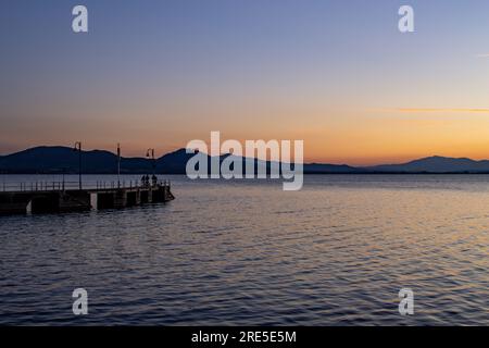 Lac avec jetée au coucher du soleil. Paysage italien relaxant au coucher du soleil en automne. Lac Trasimeno au coucher du soleil Banque D'Images