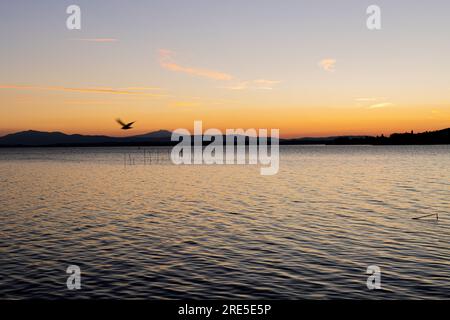 Lac avec jetée au coucher du soleil. Paysage italien relaxant au coucher du soleil en automne. Lac Trasimeno au coucher du soleil Banque D'Images