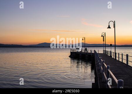 Lac avec jetée au coucher du soleil. Paysage italien relaxant au coucher du soleil en automne. Lac Trasimeno au coucher du soleil Banque D'Images