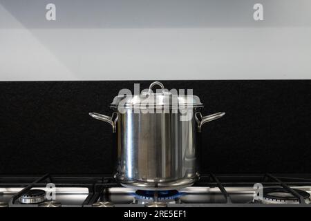 Couvrez une casserole avec laquelle vous cuisinez avec un couvercle. Pot en acier est couvert pour la cuisson sur cuisinière à gaz. Concept de bonnes pratiques pour les économies d'énergie nécessaires Banque D'Images