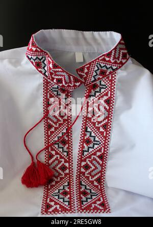 Partie de vêtements ukrainiens traditionnels blancs avec des motifs de broderie isolés sur fond noir Banque D'Images