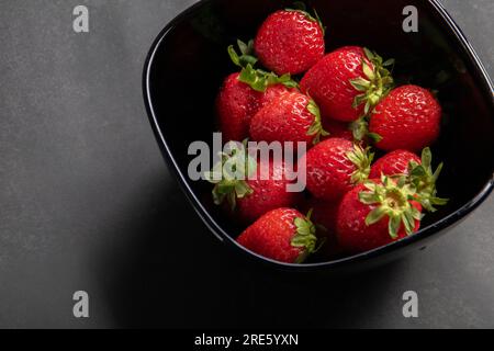 photo d'une fraise mûre et juteuse couchée dans un bol. Banque D'Images