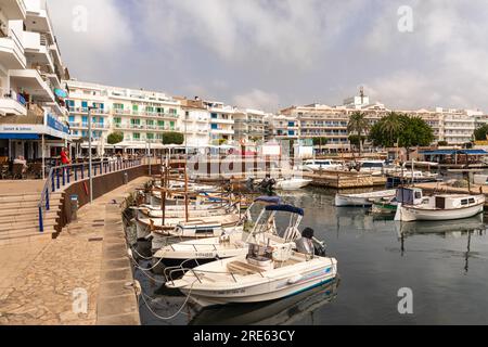 Port de Cala Bona avec bateaux de pêche traditionnels et entouré d'hôtels, restaurants et bars, Cala Bona, Majorque (Majorque), Îles Baléares, Espagne Banque D'Images