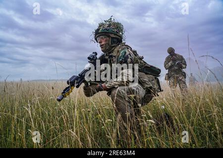 Hohenfels, Allemagne. 21 juillet 2023. Un cadet officier de l'armée britannique de la Royal Military Academy Sandhurst se prépare pour un assaut alors qu'un instructeur prend des notes lors de Dynamic Victory 23-2 au joint multinational Readiness Center, le 21 juillet 2023 près de Hohenfels, en Allemagne. Crédit : CPS. Leonard Beckett/US Army photo/Alamy Live News Banque D'Images