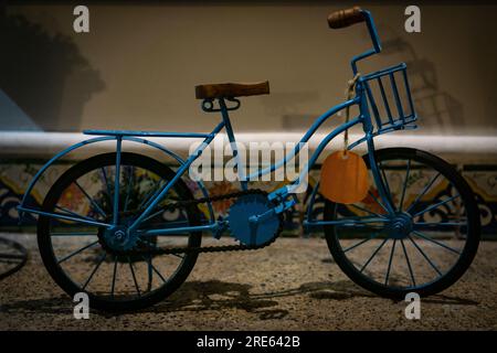 Jouet de vélo jaune en métal vintage avec des éléments en bois sur une étagère comme décor à la maison Banque D'Images