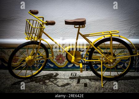 Jouet de vélo jaune en métal vintage avec des éléments en bois sur une étagère comme décor à la maison Banque D'Images