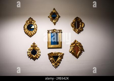 Collection de petits miroirs accrochés au mur avec des cadres vintage dorés Banque D'Images