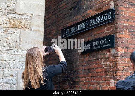 Touriste féminine prenant la photo de St Helen passage, Oxford, menant à Turf Tavern. Banque D'Images