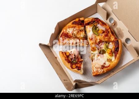 Deux restes de pizza différents dans une boîte en carton ouverte isolée sur fond blanc. Banque D'Images