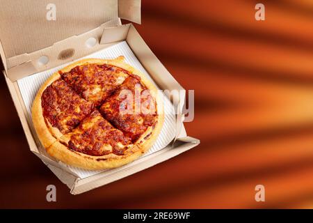 Pizza Margherita dans une boîte sur un fond brun Banque D'Images