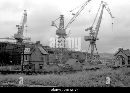 Le porte-avions HMS Illustrious en cours de construction à Swan Hunters Wallsend travaille sur la rivière Tyne avec le Ship Inn au premier plan en 1977 Banque D'Images