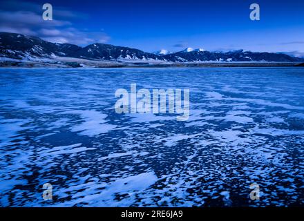 Le lac Ennis, gelé en hiver et les sommets espagnols, au crépuscule. Comté de Madison, Montana, États-Unis. Banque D'Images