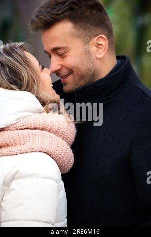 Heureux couple amoureux dans le parc d'hiver. Jeune bel homme et femme en vêtements d'hiver s'embrassant et se regardant avec tendresse. Hiver romantique Banque D'Images