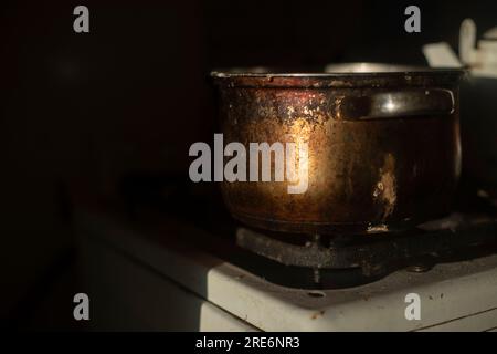 Pot rouillé dans la cuisine. Vieux plats. Détails de la cuisine. Lumière sur métal. Banque D'Images