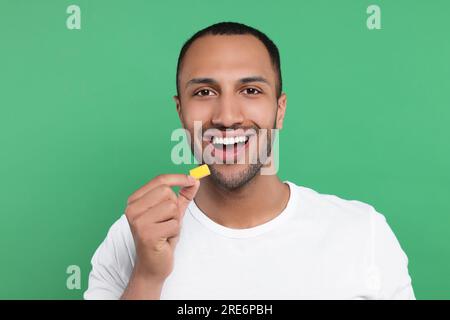 Portrait de jeune homme heureux avec de la gomme à bulles sur fond vert Banque D'Images