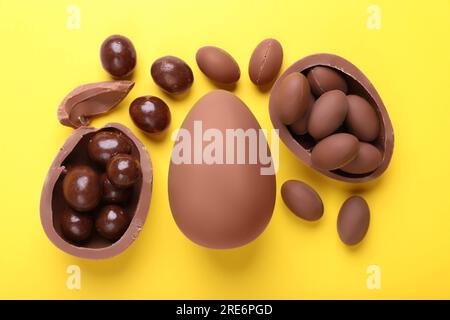 Délicieux œufs en chocolat et bonbons sur fond jaune, ponte plate Banque D'Images