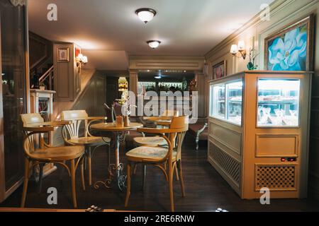 Une table en bois vide et des chaises dans un restaurant la nuit à Plovdiv, Bulgarie Banque D'Images