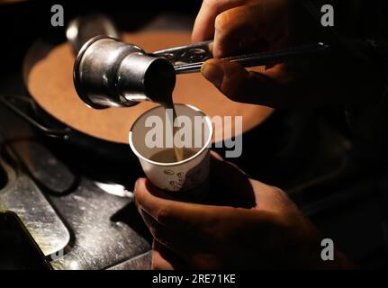 Le Caire, Égypte. 25 juillet 2023. Un homme prépare un café dans son café de voiture de rue au Caire, en Égypte, le 25 juillet 2023. Crédit : Wang Dongzhen/Xinhua/Alamy Live News Banque D'Images