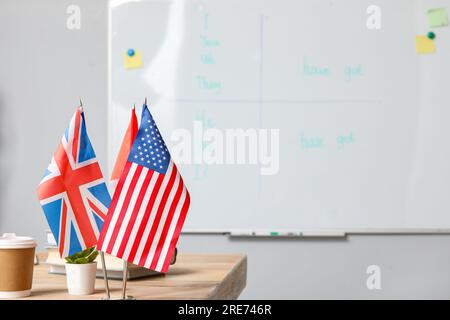 Différents drapeaux sur la table dans la salle de classe d'anglais, closeup Banque D'Images