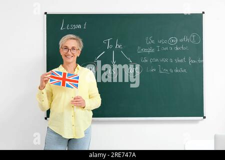 Professeur d'anglais féminin avec drapeau britannique dans la salle de classe Banque D'Images