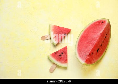 Composition avec de savoureux bâtons de pastèque sur fond jaune Banque D'Images