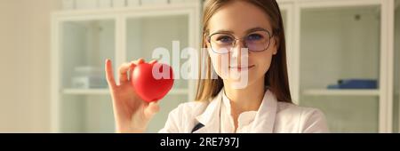 Médecin cardiologue tenant le cœur rouge en clinique Banque D'Images