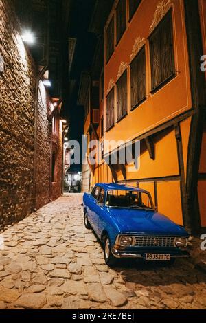 Une voiture bleu royal Moskvitch 412 en très bon état garée dans une rue la nuit dans la vieille ville de Plovdiv, Bulgarie Banque D'Images