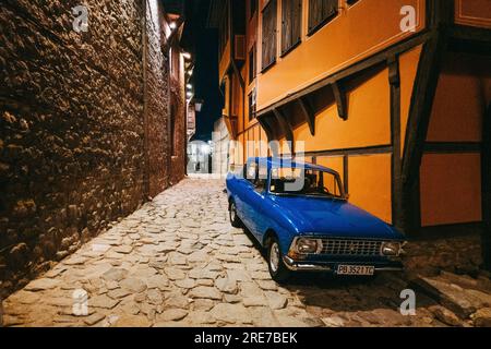 Une voiture bleu royal Moskvitch 412 en très bon état garée dans une rue la nuit dans la vieille ville de Plovdiv, Bulgarie Banque D'Images