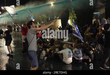 La police utilise un canon à eau pour disperser des manifestants anti-gouvernementaux bloquant une route près de la Cour suprême lors d'une manifestation contre le gouvernement de droite dure d'Israël et l'approbation du projet de loi judiciaire par le Parlement aujourd'hui le 24 juillet 2023 à Jérusalem, Israël Banque D'Images