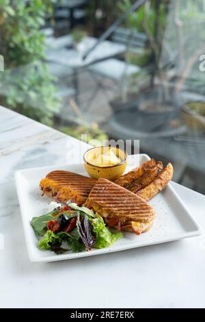 Sandwich panini Burger. Pommes de terre frites avec salade et trempette. Vue de dessus d'arrière-plan floue Banque D'Images