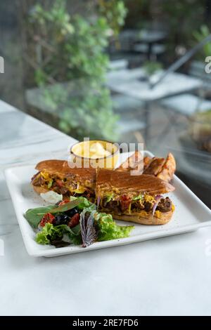 Sandwich panini Burger. Pommes de terre frites avec salade et trempette. Vue de dessus d'arrière-plan floue Banque D'Images