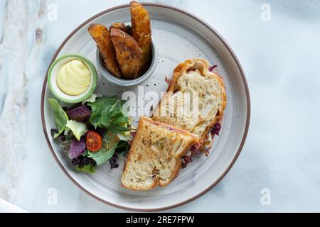 Sandwich panini Burger. Pommes de terre frites avec salade et trempette. Vue de dessus d'arrière-plan floue Banque D'Images