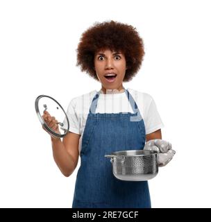 Jeune femme émotionnelle dans le tablier tenant le pot de cuisson sur fond blanc Banque D'Images