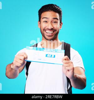 Voyage, billet et portrait de l'homme asiatique heureux pour les vacances ou le vol de vacances isolé dans un studio bleu fond. Sourire, gagner et jeune personne Banque D'Images