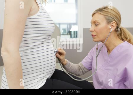 jeune femme prégante en attente d'une visite chez un bébé médecin Banque D'Images